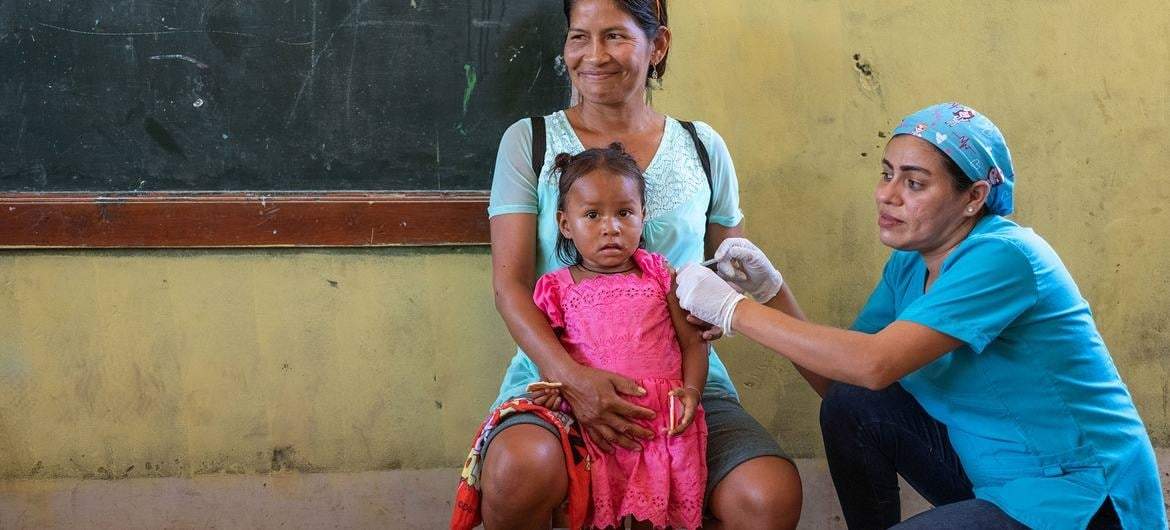 Una niña de dos años recibe la vacuna contra la gripe en un dispensario móvil de Loreto, Perú