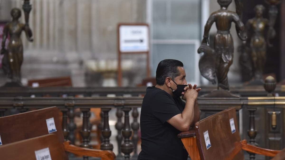 Un hombre con cubrebocas reza en la Catedral Metropolitana