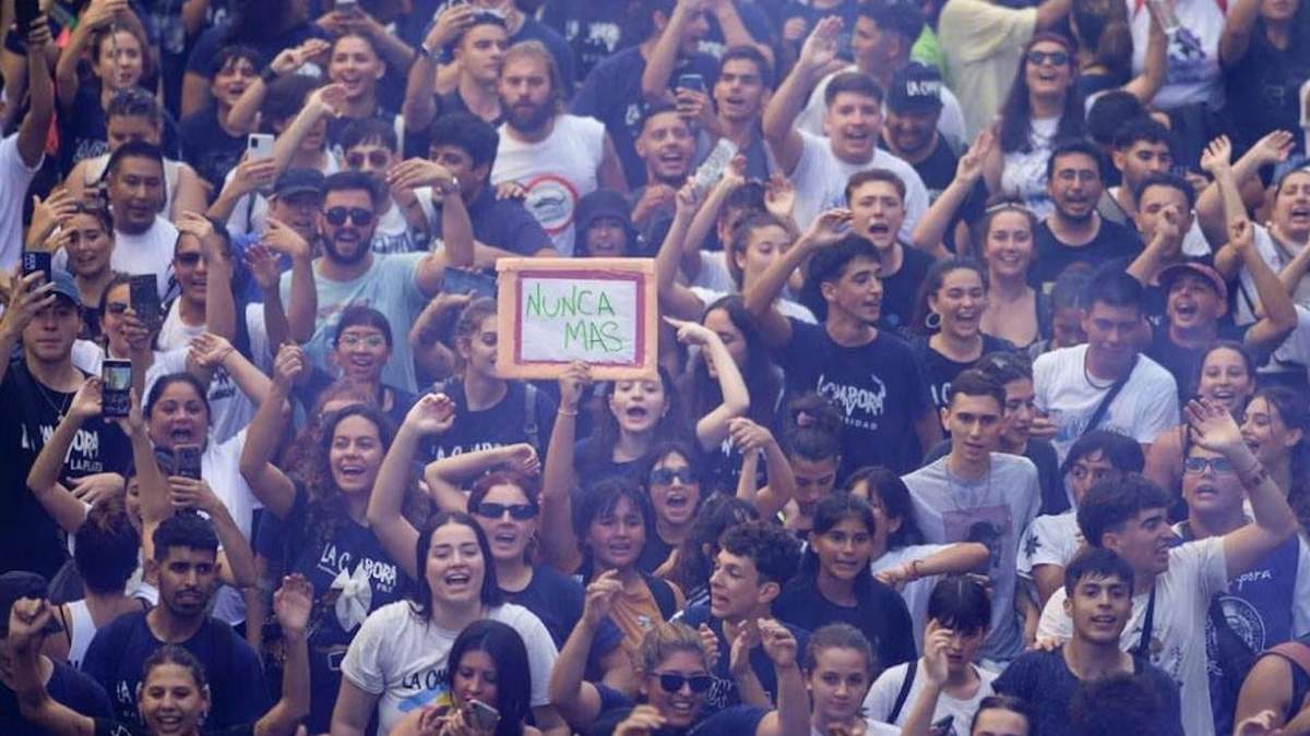 Una manifestante sostiene una pancarta con la leyenda "Nunca más" durante una marcha para conmemorar el aniversario del golpe militar de 1976