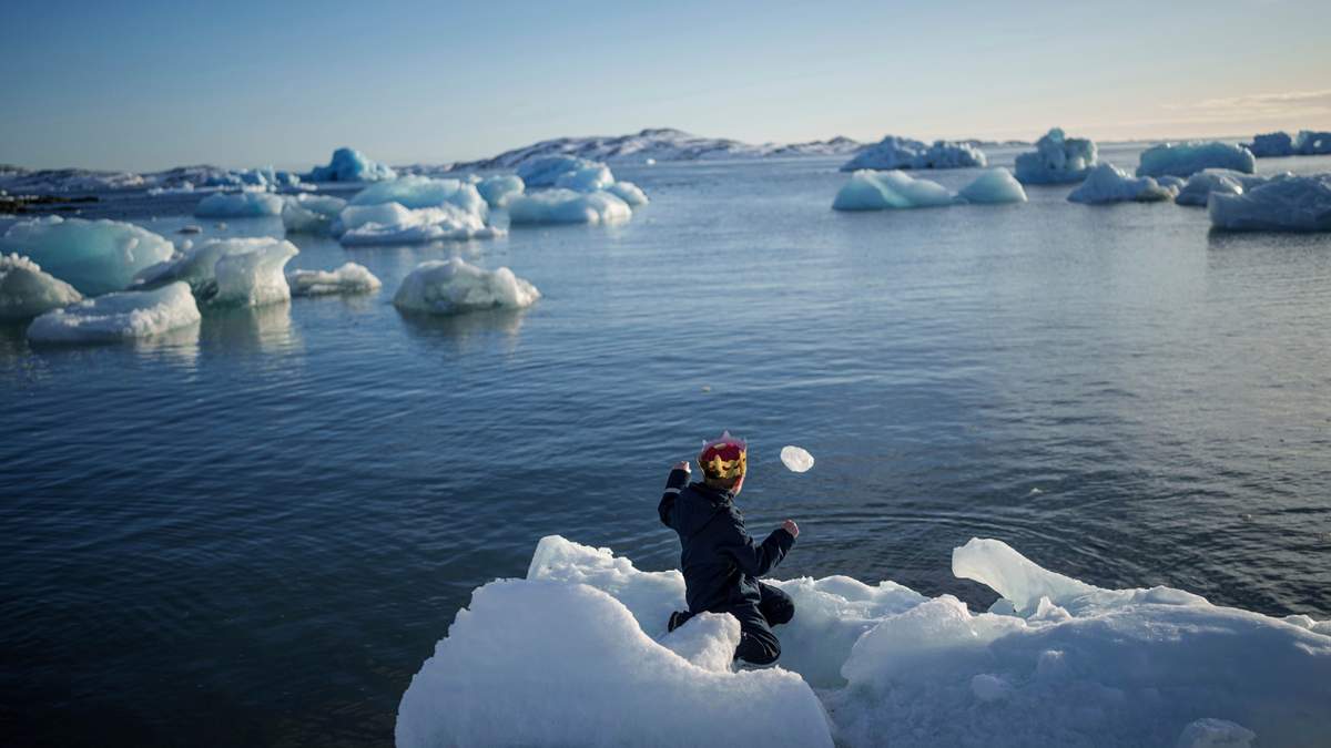 Un niño lanza hielo al mar en Nuuk, Groenlandia, el 11 de marzo de 2025
