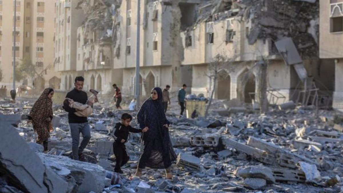 Un grupo de palestinos entre edificios destruidos por los bombardeos del Ejército de Israel contra Jan Yunis, en el sur de la Franja de Gaza