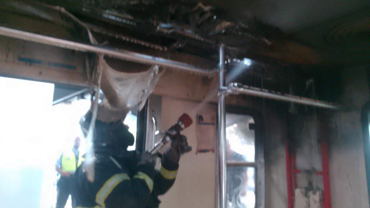 Un bombero apaga el fuego en el vagón del Tren Ligero