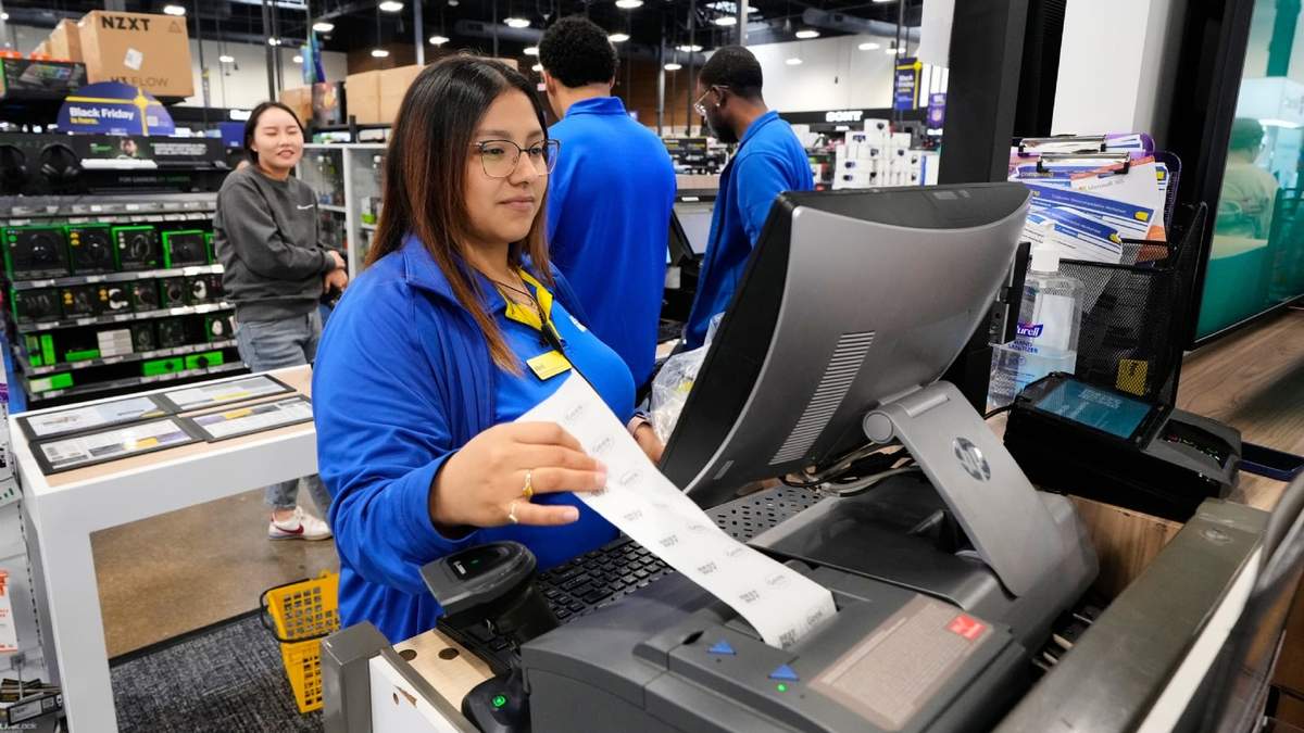 Abril Renteria, asesora certificada de Apple, ayuda a un cliente a terminar su compra en una tienda Best Buy, el miércoles 26 de noviembre de 2025, en Dallas
