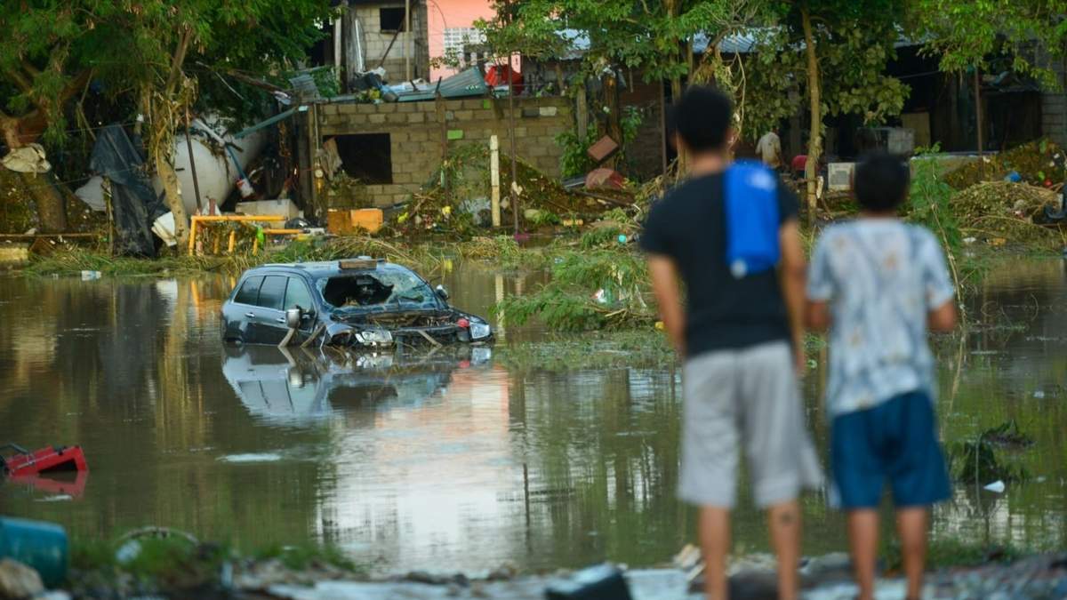 Dos jóvenes observan las inundaciones en Poza Rica
