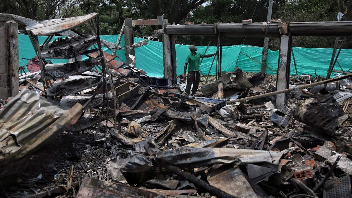 Un trabajador se encuentra en lo que queda de un almacén de repuestos después de que un coche bomba explotara detrás de una comisaría en Timba, Cauca