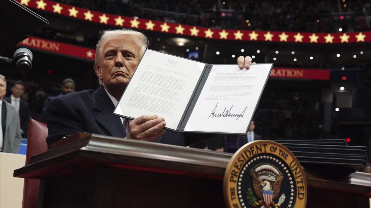 El presidente Donald Trump enseña órdenes firmadas