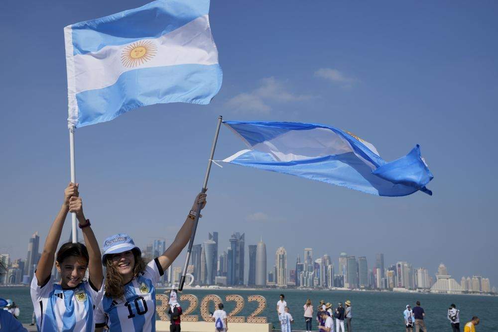 Un par de hinchas de Argentina sostienen su bandera en la víspera del partido del Mundial contra Arabia Saudita, el lunes 21 de noviembre de 2022, en Doha, Qatar