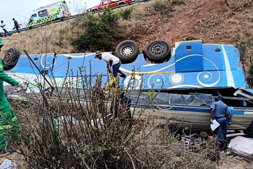 En esta fotografía, proporcionada por el Departamento de Transporte y Seguridad Comunitaria de Sudáfrica, se ve a agentes de policía y equipos de rescate buscando víctimas en un autobús volcado en el terraplén, en Louis Trichardt, Sudáfrica, el domingo 12 de octubre de 2025.
