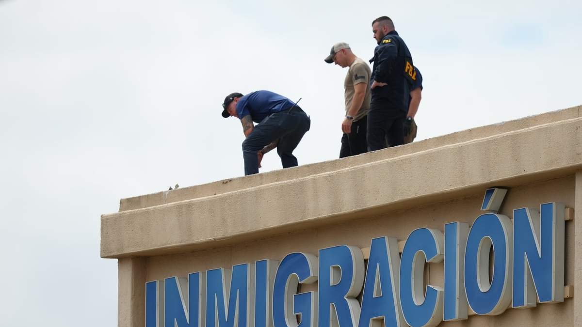Agentes inspeccionan el tejado de un edificio cerca de la escena de un tiroteo en una oficina de lCE en Dallas
