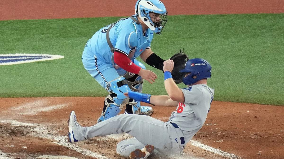 Will Smith, de los Dodgers de Los Ángeles, anota frente al mexicano Alejandro Kirk, catcher de los Azulejos de Toronto, en el sexto juego de la Serie Mundial,