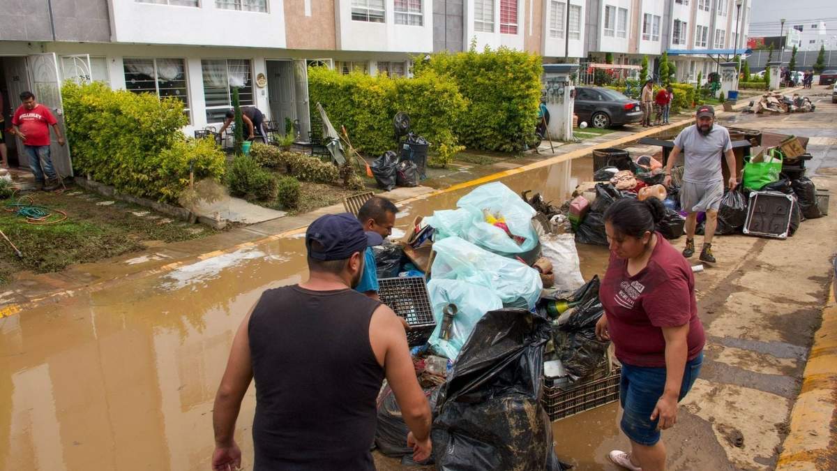Habitantes de Valle de Chalco sacas sus pertenencias de sus casas tras la inundación del martes