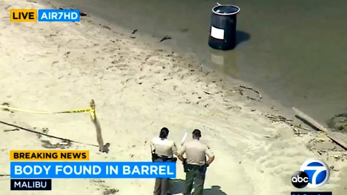 Policías observa un barril con un cadáver en su interior, en Malibu Lagoon