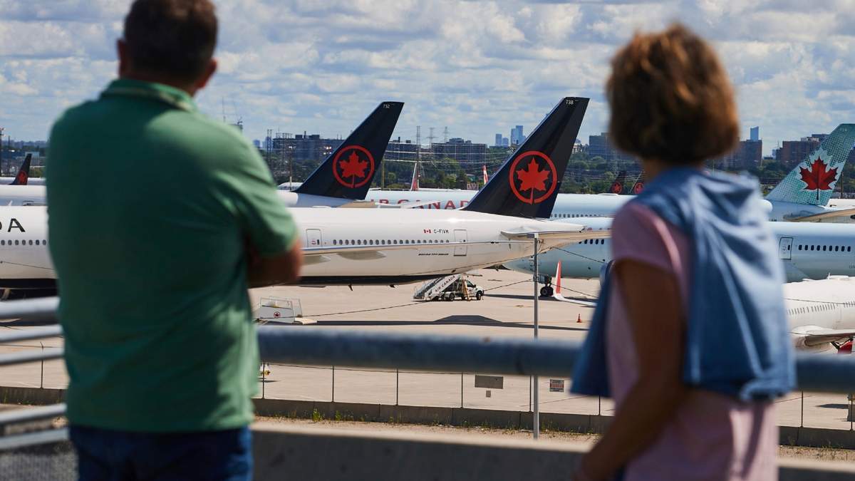 Viajeros observan los aviones de Air Canada en tierra debido a la huelga de sobrecargos de la aerolínea, en el Aeropuerto Internacional Pearson de Toronto