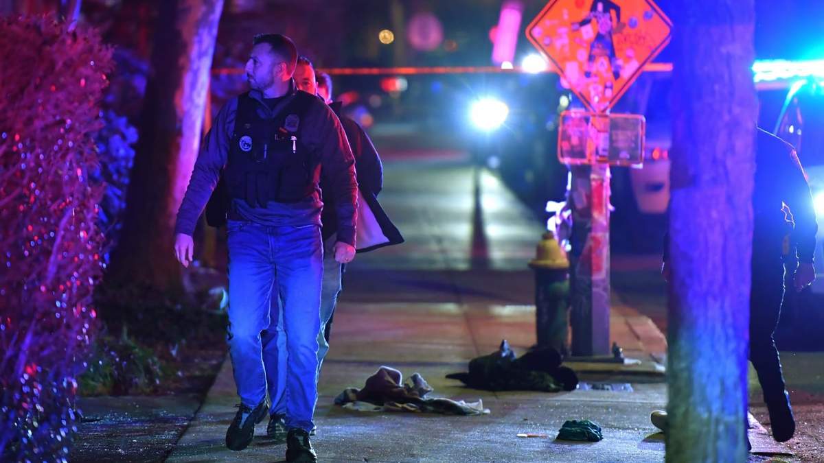 Un policía pasa entre prendas de ropa en una acera cerca de la entrada de la Universidad de Brown, el sábado 13 de diciembre de 2025 en Providence, Rhode Island durante la investigación de un tiroteo