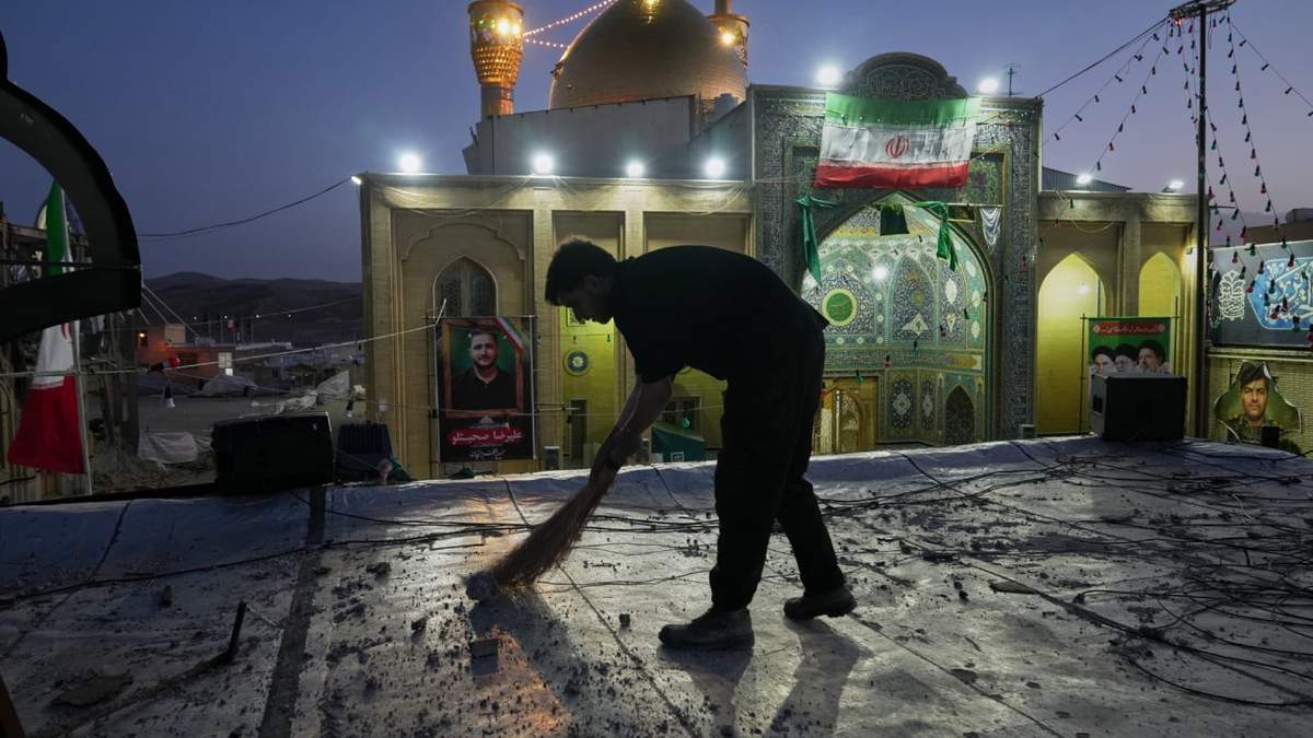 Un trabajador limpia una zona dentro del complejo Grand Hosseiniyeh, con la mezquita visible al fondo, que según las autoridades fue alcanzada por ataques aéreos estadounidenses e israelíes el martes en Zanjan, Irán