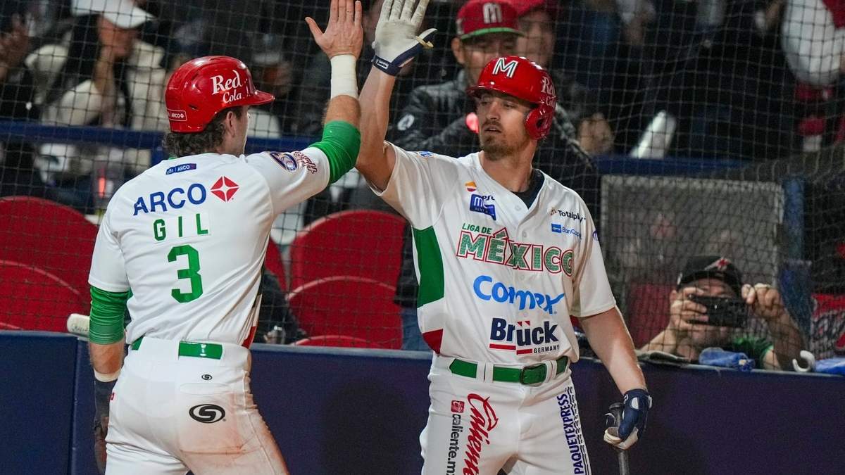 Mateo Gil festeja con Donovan Casy, su compañero de los Charros de Jalisco, tras anotar ante los Indios de Mayagüez en un juego de la Serie del Caribe disputado en Mexicali