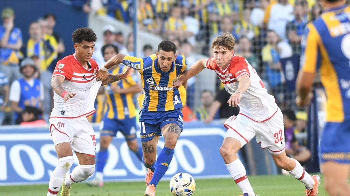 Ángel Di María entre dos rivales de Estudiantes. Estuvo tenso el partido en Rosario