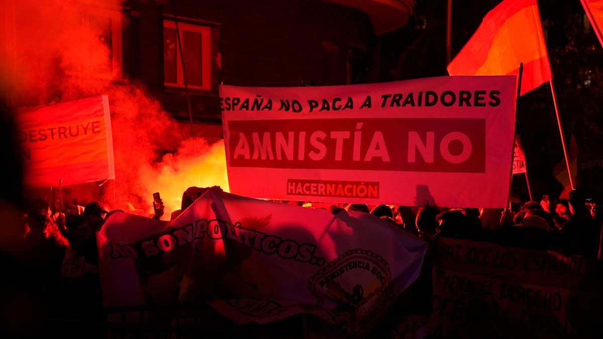 Bengalas encendidas durante la protesta cerca de la sede del Partido Socialista Obrero Español