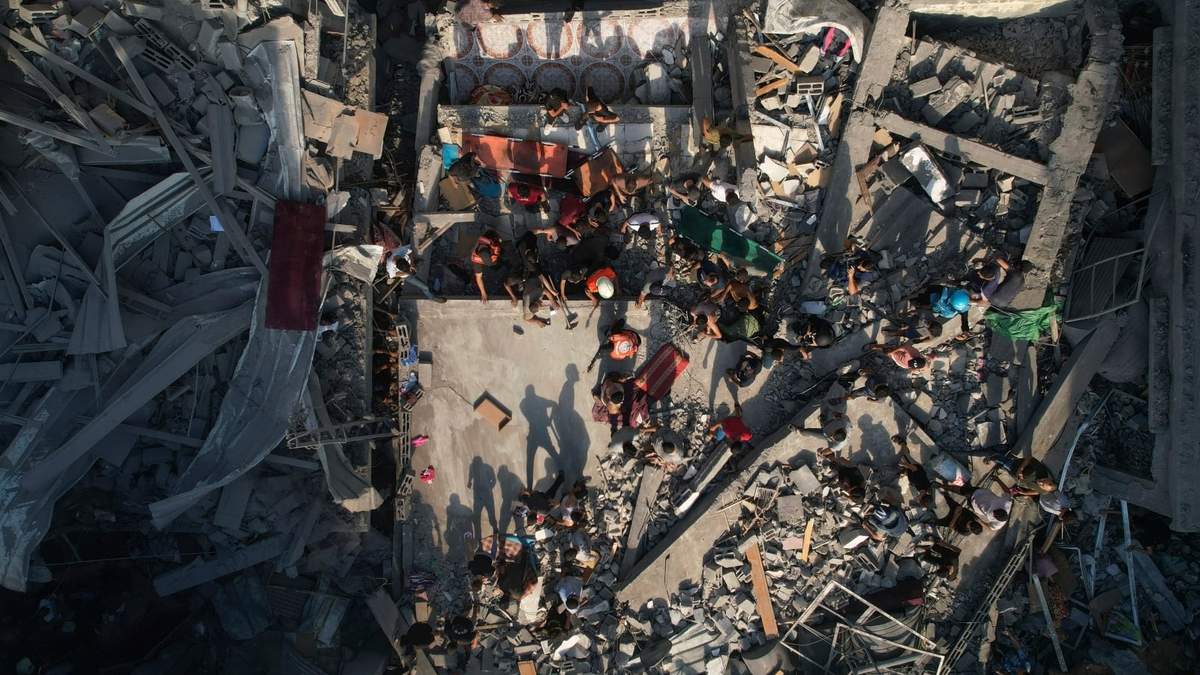 Palestinos inspeccionan los escombros de edificios alcanzados por un ataque aéreo israelí en el campo de refugiados Al Shati