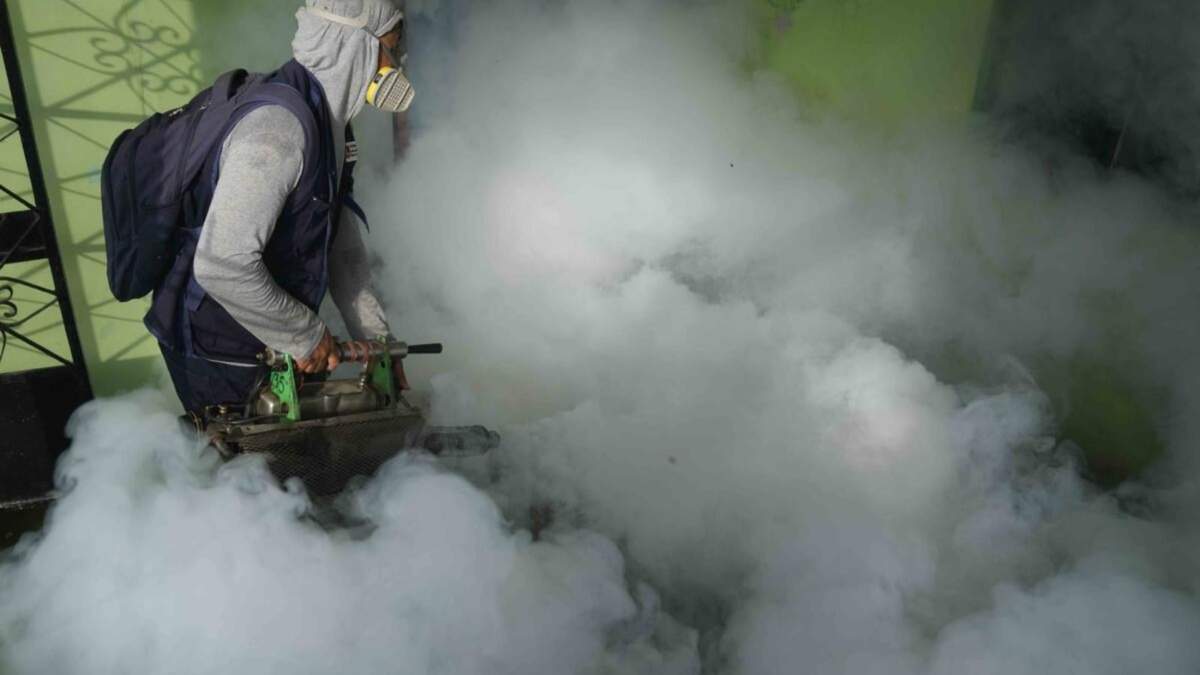 Un trabajador de la salud fumiga mosquitos dentro de una casa para ayudar a mitigar la propagación del dengue en el área de Las Peñitas de Talara, Perú