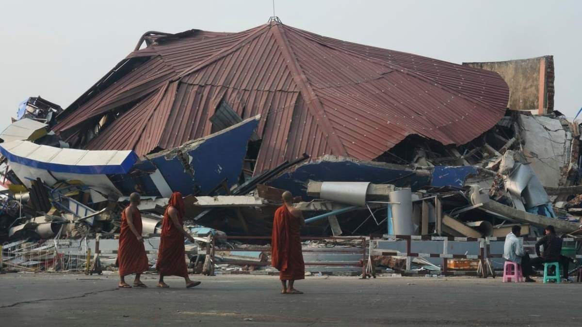 Monjes budistas caminan junto a un edificio derrumbado tras un potente terremoto en Naypyitaw, Birmania