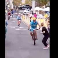 Ciclista arrolla en una carrera a una espectadora que cruzó distraída (Video)