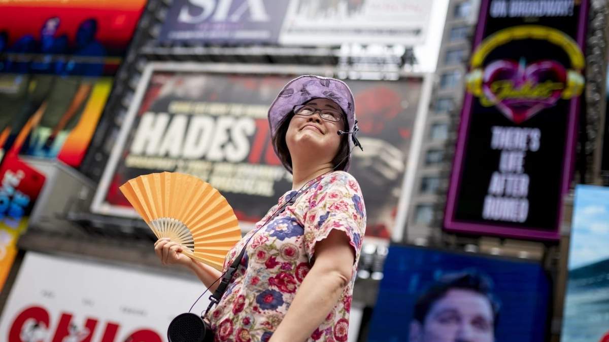 Una mujer se abanica por el calor en Times Square, NY