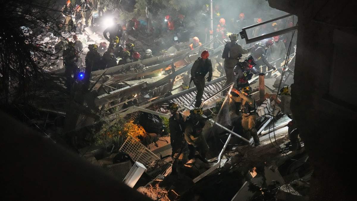 Fuerzas de seguridad y equipos de rescate israelíes trabajan entre los escombros de un edificio residencial alcanzado por un misil iraní en Haifa, Israel, el domingo 5 de abril de 2026