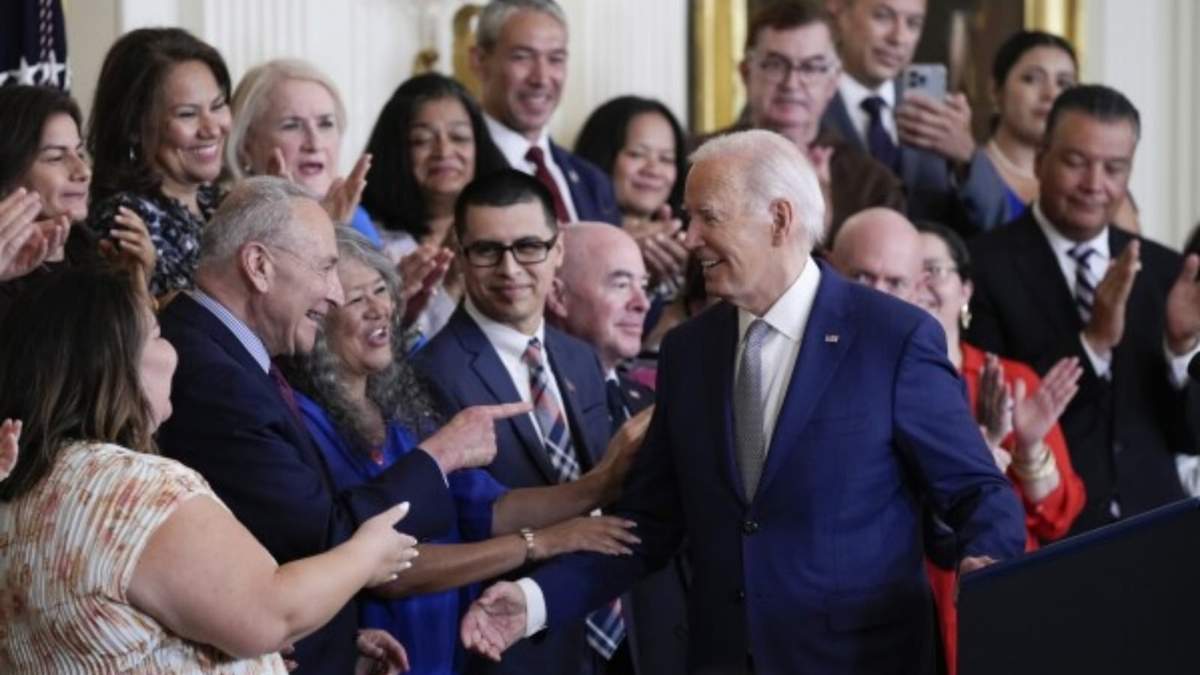 El presidente Joe Biden saluda a personas en el estrado después de su discurso durante un evento para conmemorar el 12do aniversario del programa Acción Diferida para los Llegados en la Infancia