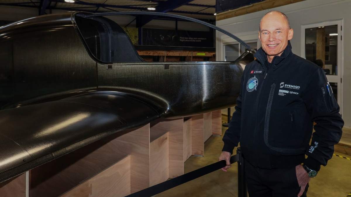 El pionero suizo de la aviación Bertrand Piccard posa para una fotografía en un hangar frente al Climate Impulse, un avión propulsado por hidrógeno líquido, en Les Sables d'Olonne, Francia