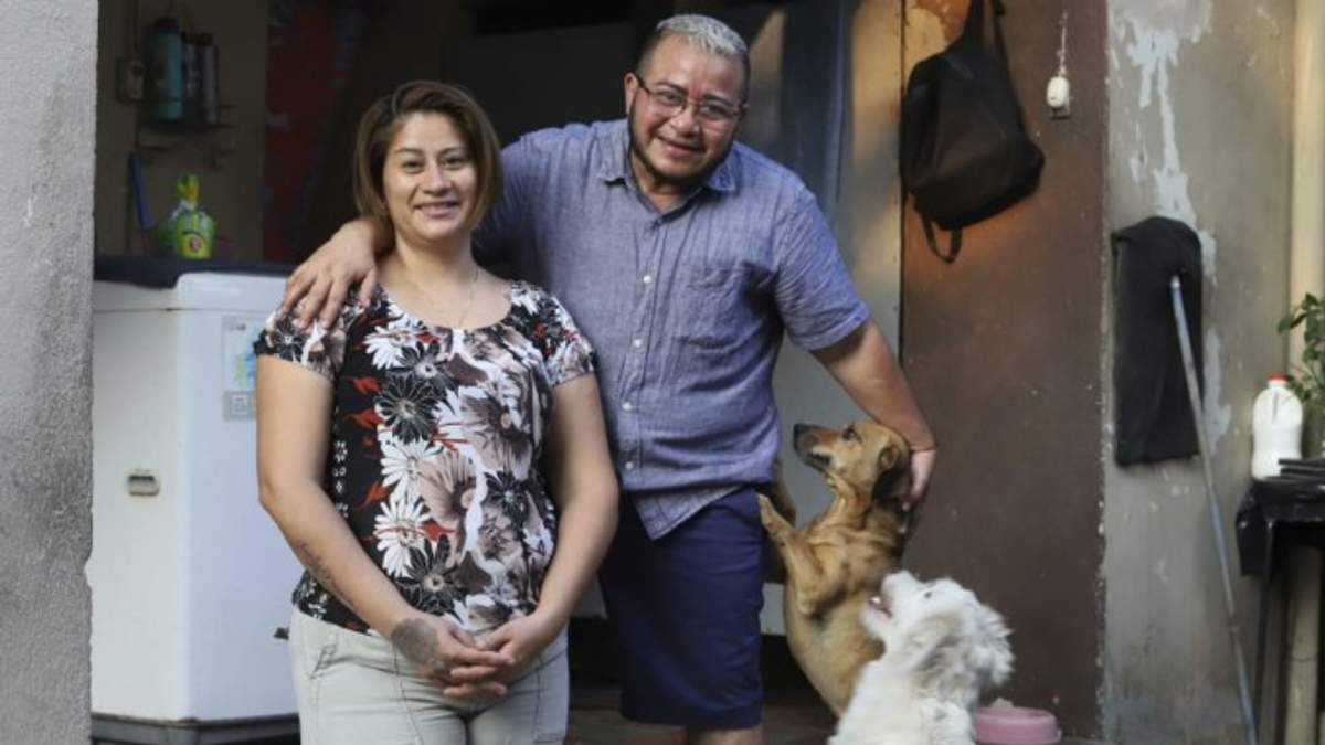 Fabricio Chicas, un hombre transgénero, a la derecha, posa para una foto con su pareja Elizabeth López y sus mascotas en su casa en San Salvador