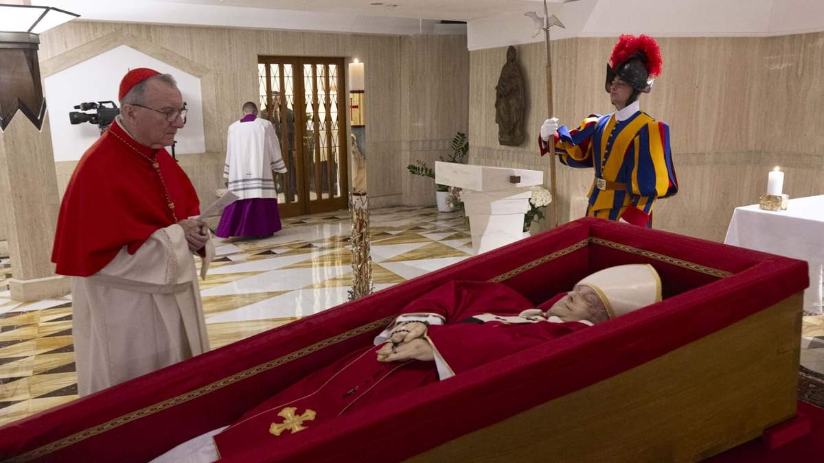 El secretario de Estado del Vaticano, el cardenal Pietro Parolin (izquierda), reza en frente del cuerpo del papa Francisco, dispuesto para el velatorio en su capilla privada en el Vaticano