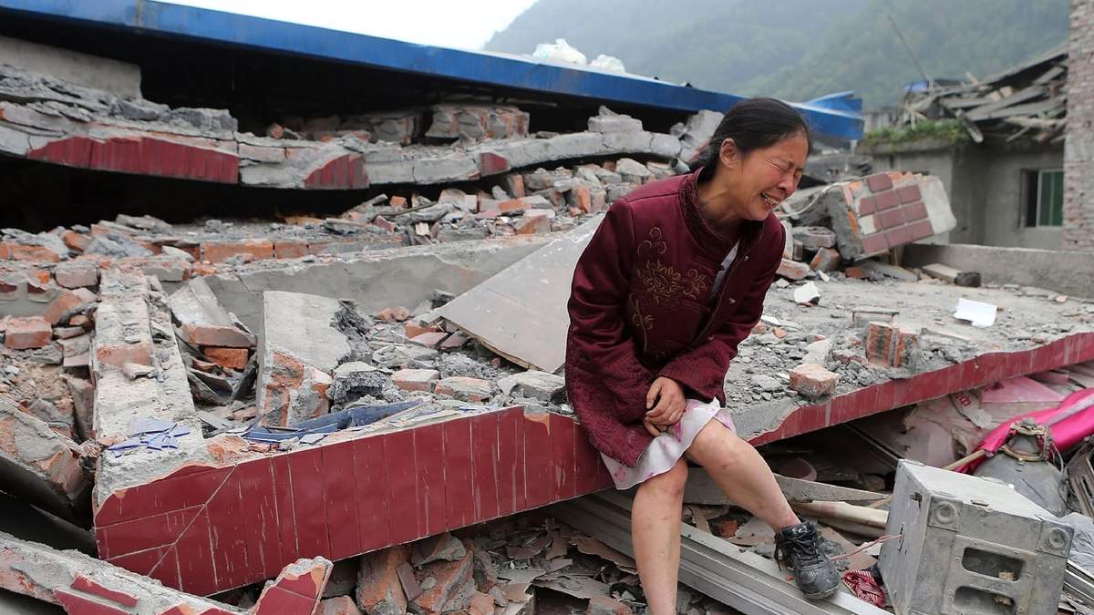 Una mujer sobre los restos de los que fuera su casa en China. Fuente: (Twitter)