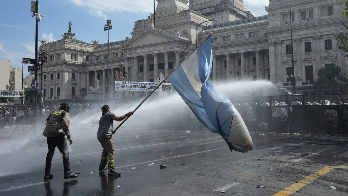 Un manifestante ondea una bandera frente al Congreso durante la marcha de sindicatos