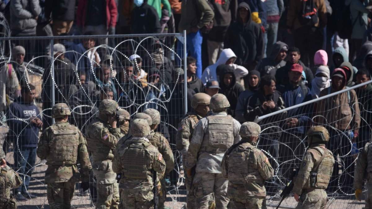 Migrantes cruzan y brincan la malla de alambre de púas en la puerta 36 de la frontera entre México y los Estados Unidos