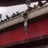 Un hombre intenta lanzarse de un puente, lo disuaden y cae en el intento de rescatarlo