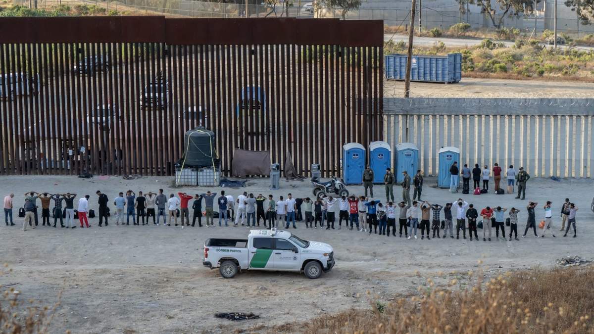 Migrantes en el muro fronterizo desde Tijuana