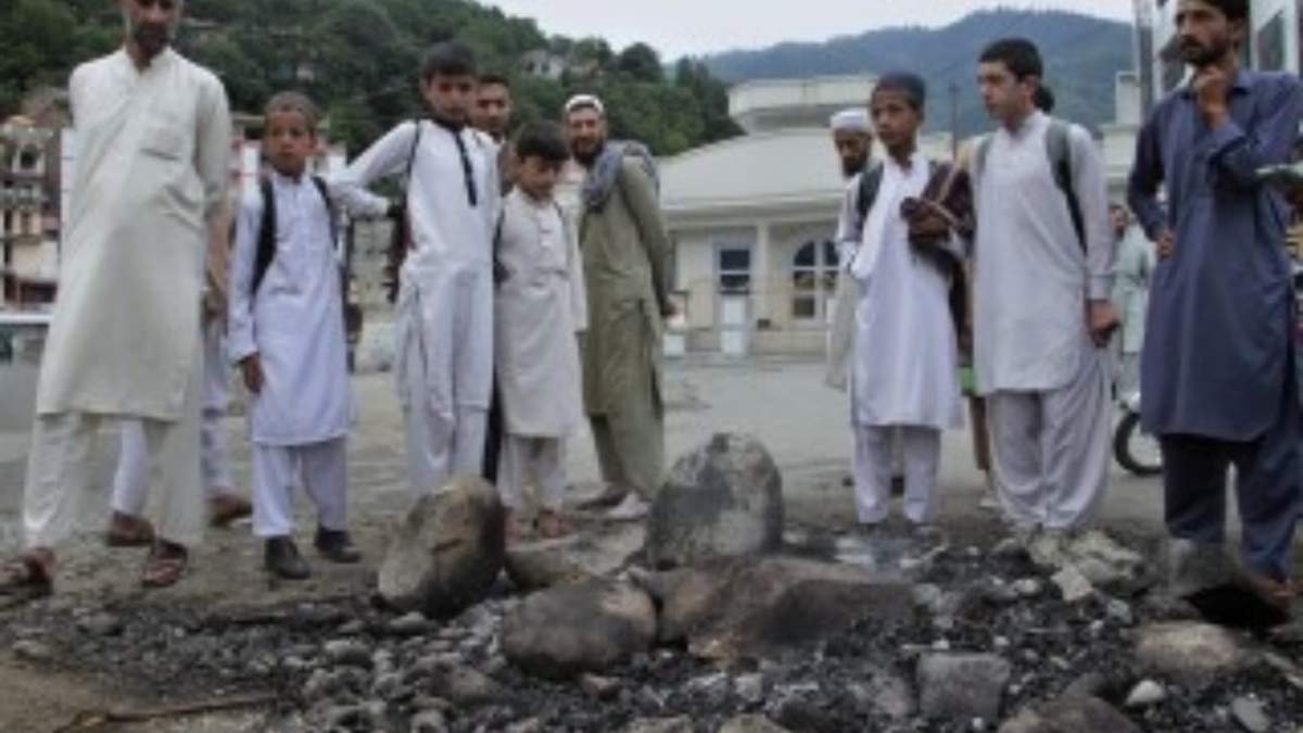 Un grupo de residentes locales en el lugar donde una turba mató y quemó a un hombre al que acusó de profanar un Corán, en Madyan, en la provincia Khyber Pakhtunkhwa del este de Pakistán