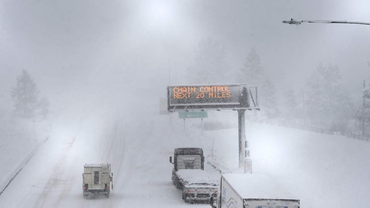 Varios vehículos circulan bajo una intensa nevada por la autopista I-80 en Truckee, California