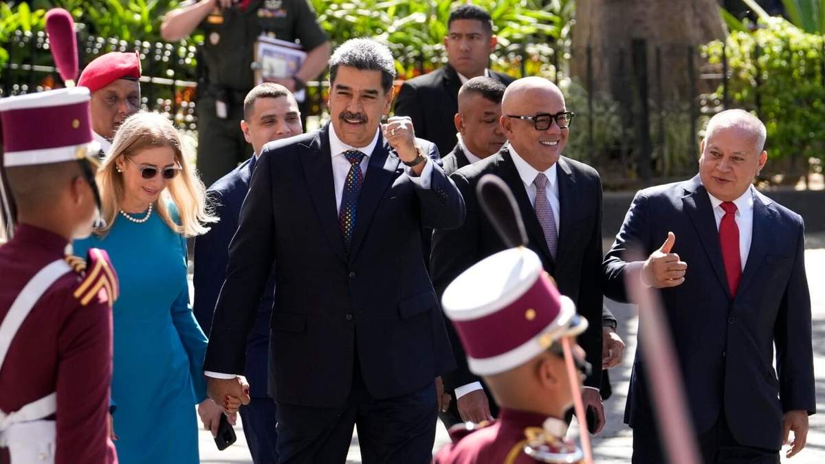 El presidente venezolano, Nicolás Maduro, hace gestos a sus seguidores mientras camina de la mano de su esposa Cilia Flores