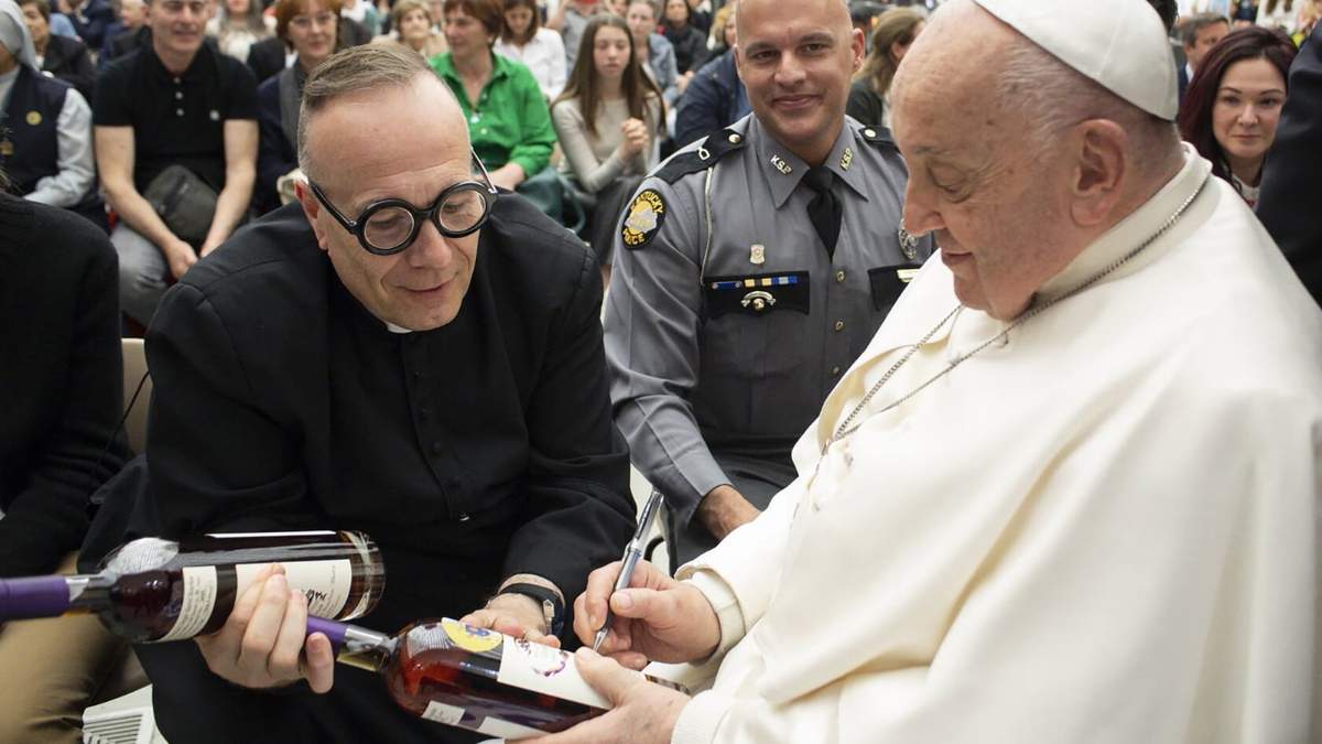 El papa Francisco autografía una botella de bourbon que sostiene el sacerdote católico de Kentucky reverendo Jim Sichko en el Vaticano el 1 de mayo de 2024