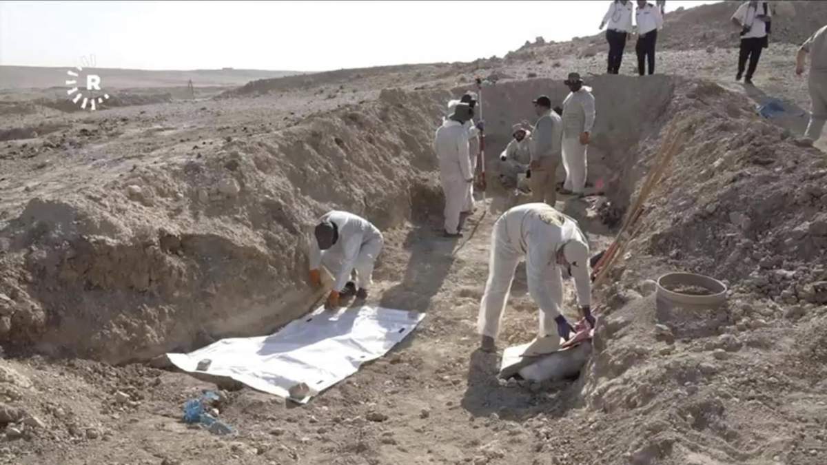 Trabajadores desentierran restos humanos en el sitio de Khasfa, cerca de la ciudad de Mosul, en el norte de Irak