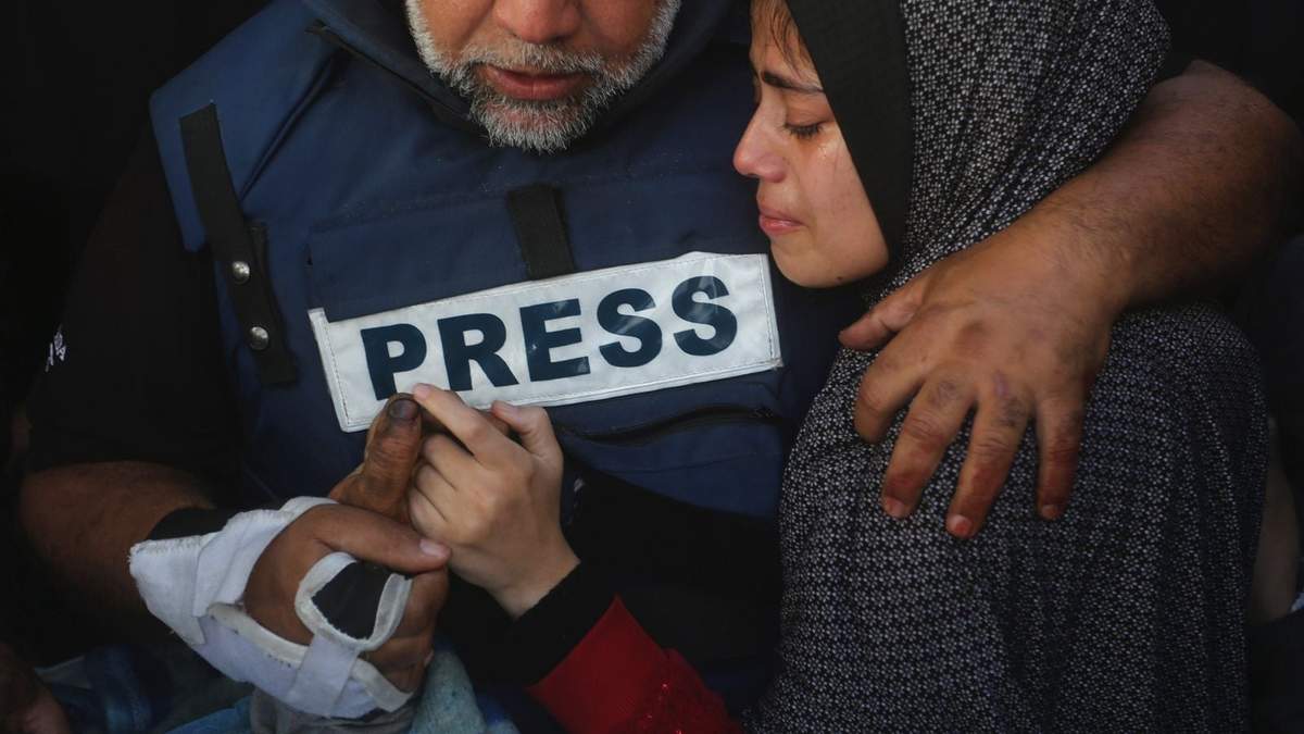 Periodista de Al Jazeera Wael Dahdouh sostiene la mano de su hijo Hamza, que también trabajó ahí y murió en un ataque aéreo israelí