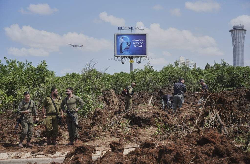 Fuerzas de seguridad israelíes inspeccionan el lugar donde según el Ejército israelí cayó un proyectil lanzado por rebeldes hutíes en la zona del Aeropuerto Internacional Ben Gurion, cerca de Tel Aviv, Israel, domingo 4 de mayo de 2025