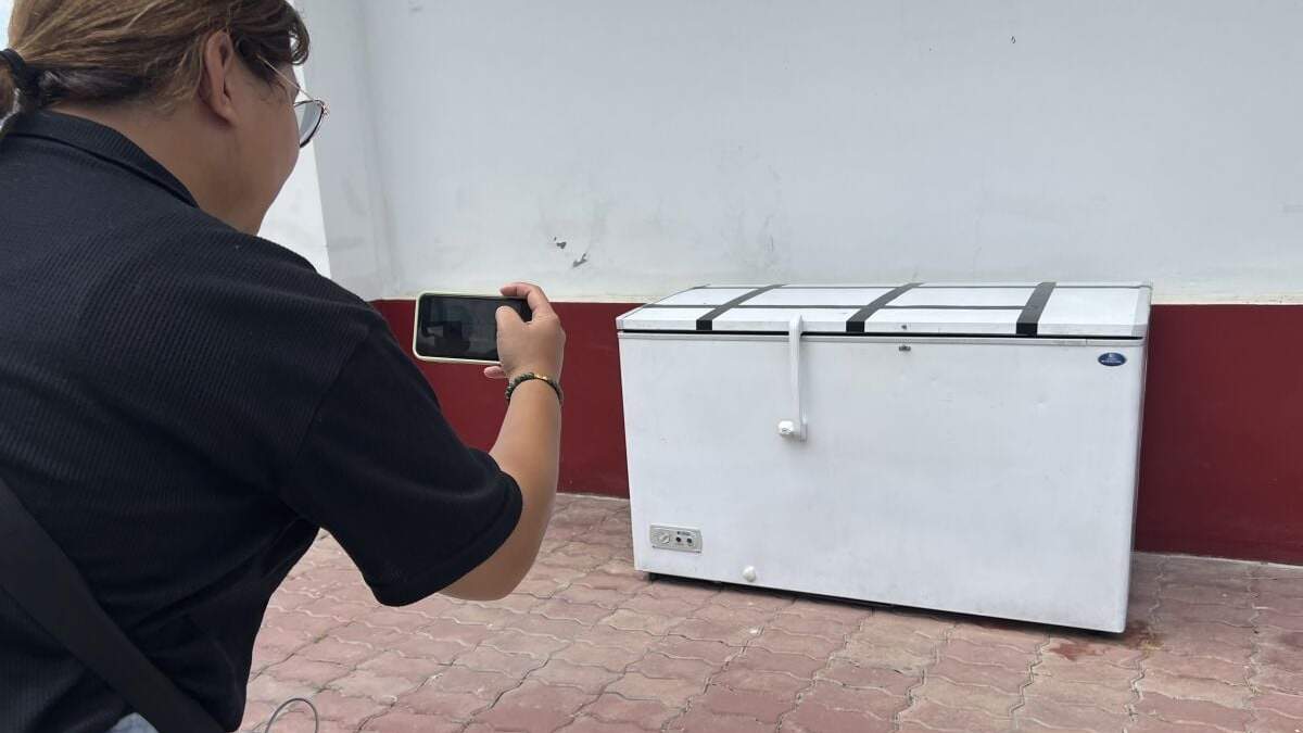 Una reportera tailandesa hace una foto a un congelador vacío en la comisaría de Nong Prue en Pattaya, provincia de Chonburi, Tailandia, el martes 11 de julio de 2023. El cuerpo descuartizado de un empresario alemán de 62 años que llevaba una semana desaparecido se encontró en el congelador de una casa en el sur de Tailandia, según dijo la policía el martes.