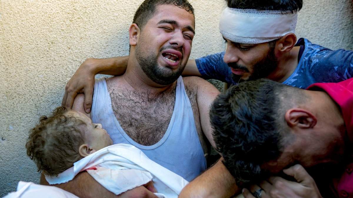 Mahmoud Mikdad llora mientras carga el cadáver de su hijo Yaman, de 21 meses