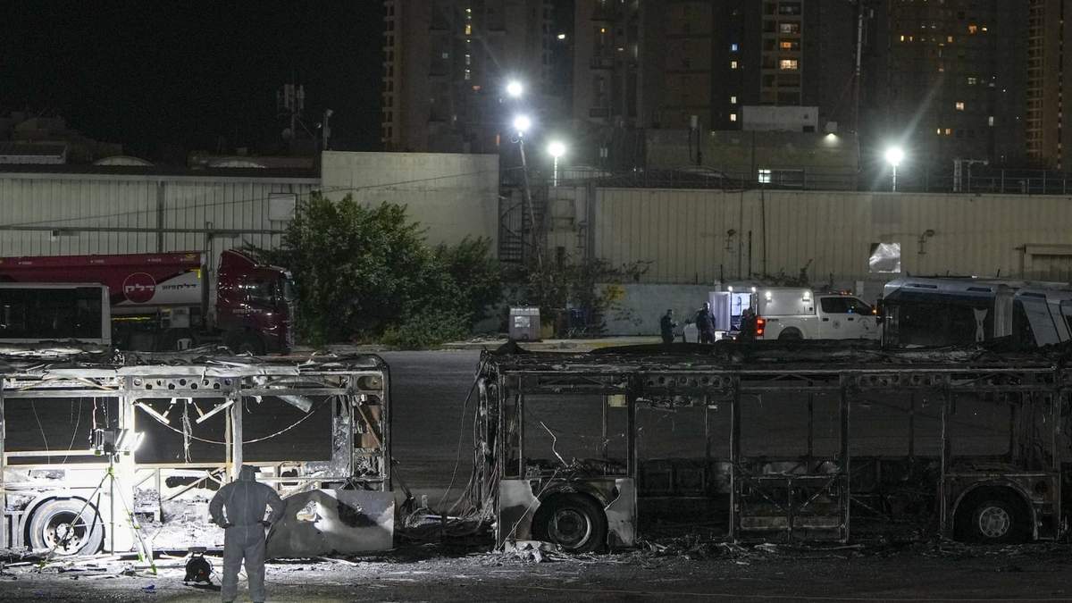 Policías israelíes revisan el lugar en donde se registro una explosión de autobús en lo que las autoridades califican como una serie de ataques milicianos en Bat Yam