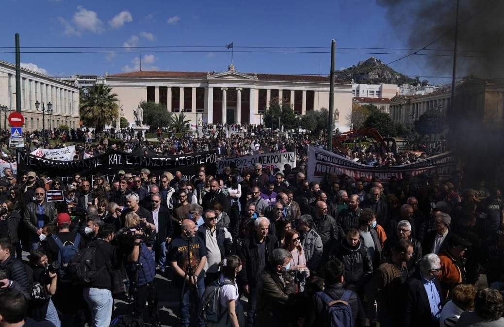 Manifestantes guardan un minuto de silencio durante una protesta por las víctimas de una tragedia ferroviaria, en el centro de Atenas