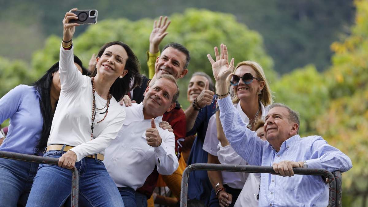 La líder opositora María Corina Machado se toma una selfie con el candidato presidencial opositor Edmundo González, a la derecha, durante una manifestación en Caracas