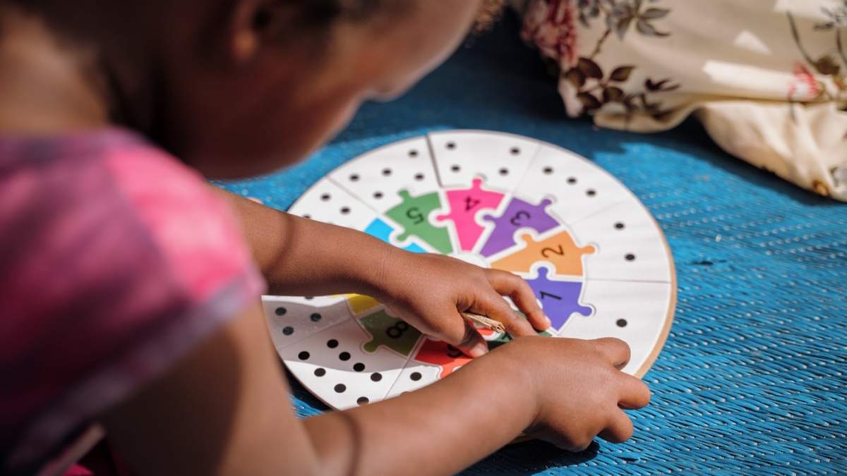 Un niño sudanés juega con un puzzle en un espacio apoyado por UNICEF en el campamento de desplazados de Sudán